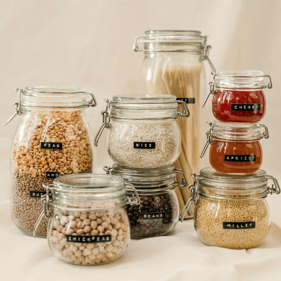 A group of clear glass jars each filled with something unique and displaying a label that tells you what it is. This is an example of how Ebb & Spruce can help you get organized. 